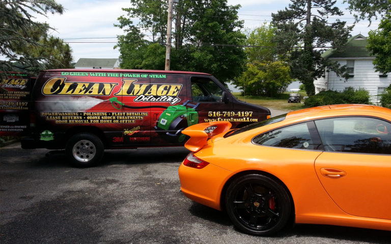 Orange Porsche 911 with Clean Image truck.