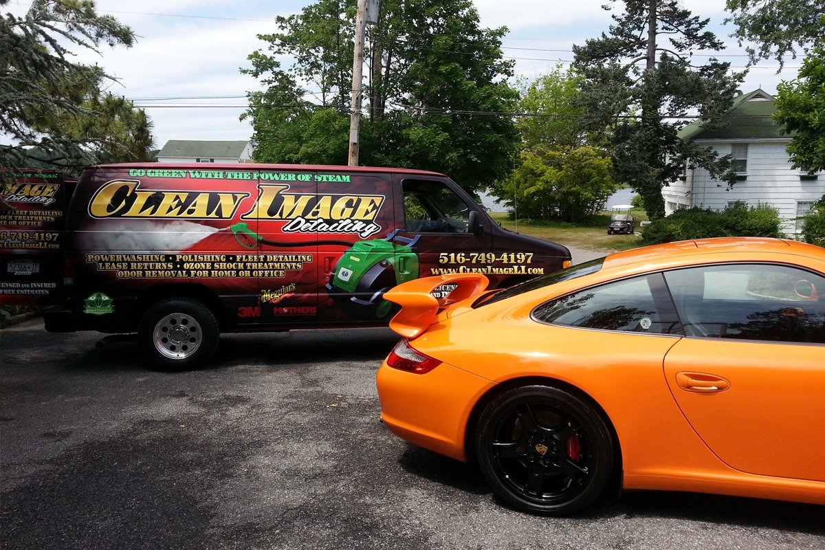 Orange Porsche 911 with Clean Image truck.