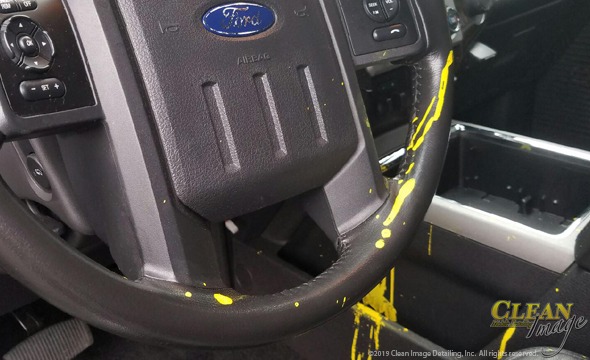 Ford steering wheel covered in yellow paint.