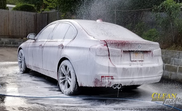 Mobile Detailing: Red BMW 3 Series in foam bath.