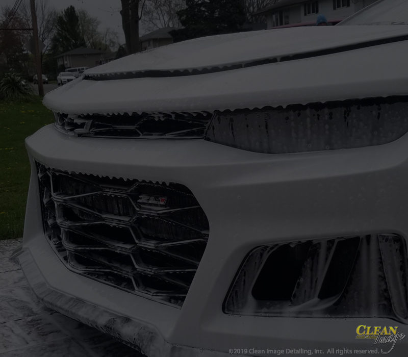 White Camaro front end in foam bath.